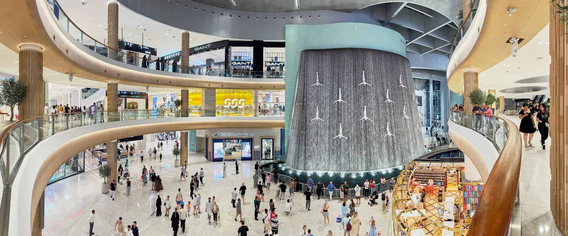 The interiors of the largest shopping mall in the world, Dubai Mall, the storefronts of branded stores and visitors to the famous mall